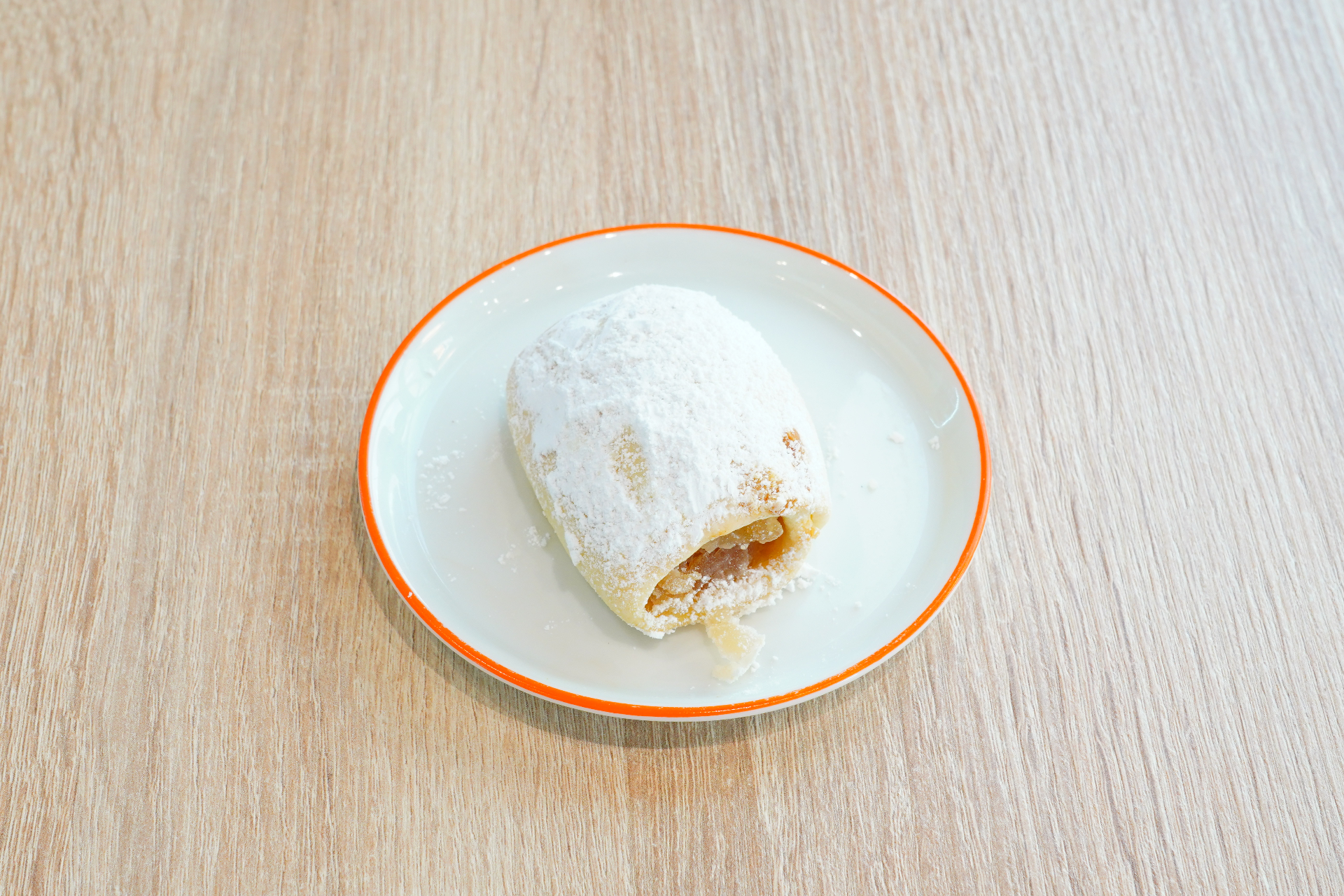 Powdered sugar-dusted almond-filled pastry on a white plate