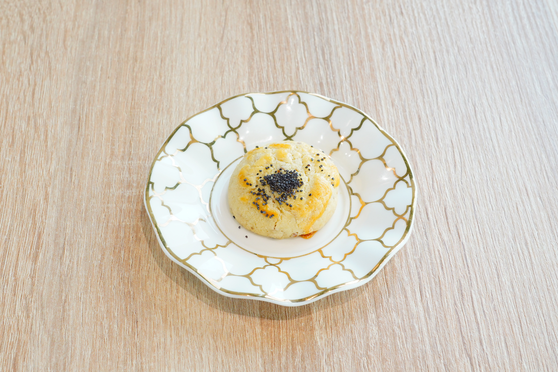Poppy seed-topped cookie on a gold-trimmed plate