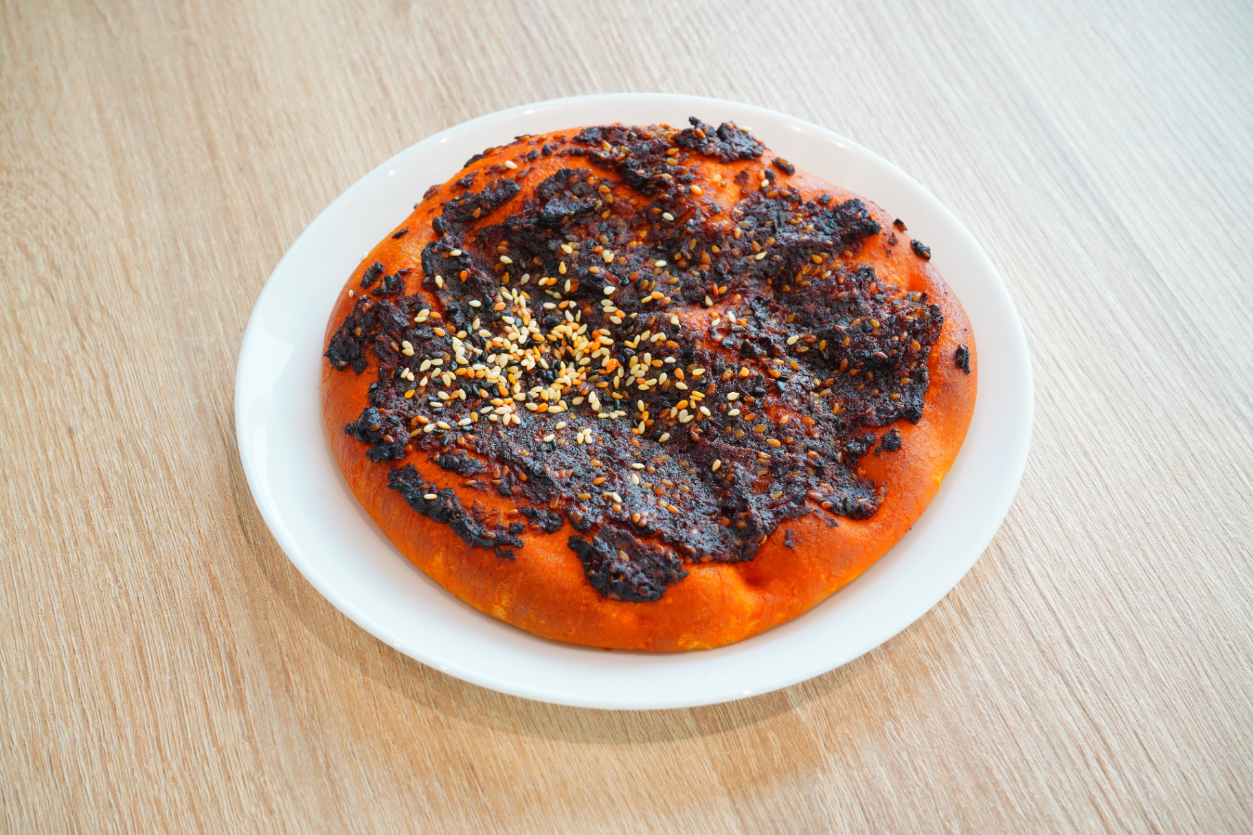 Muhammara-topped flatbread with sesame seeds