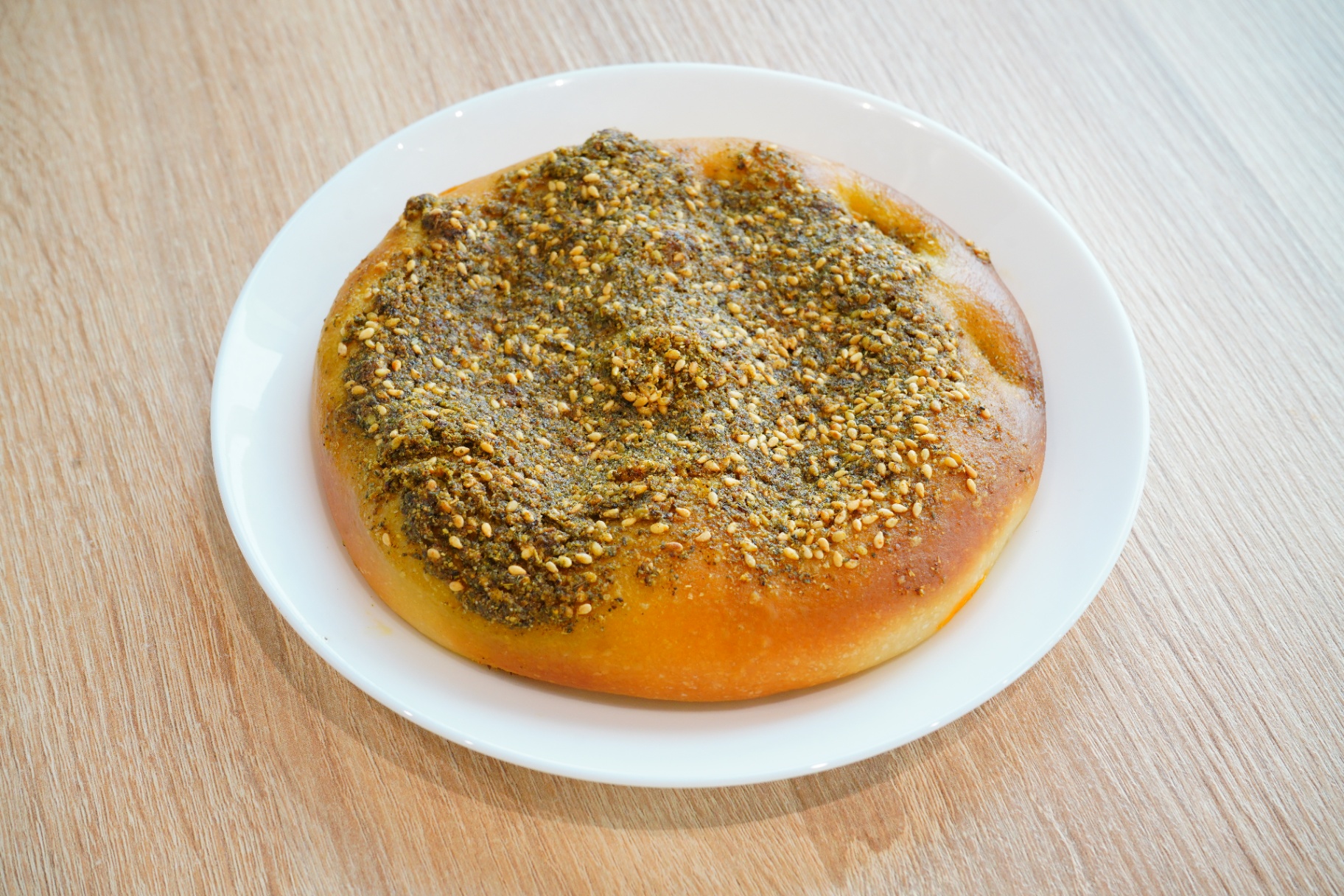 Zaatar manakish flatbread on a white plate