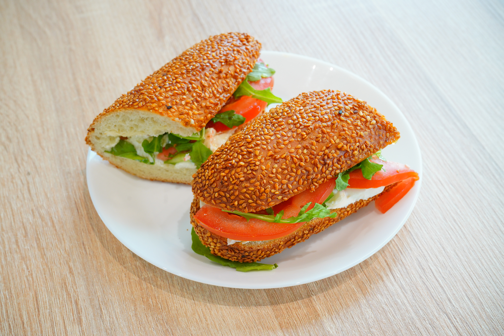 Sesame baguette sandwich with tomato and arugula