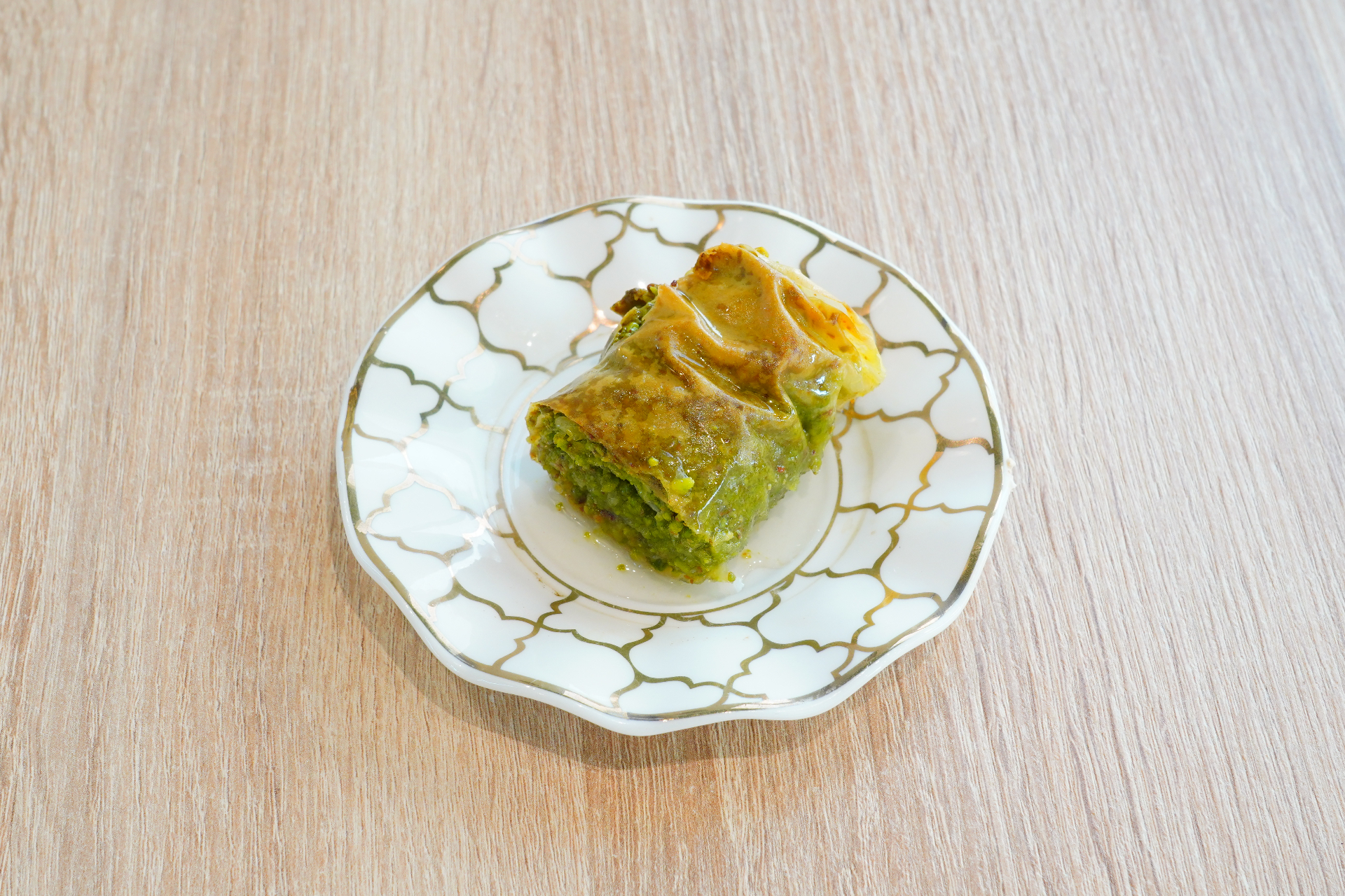 Pistachio-filled baklava roll glazed with syrup